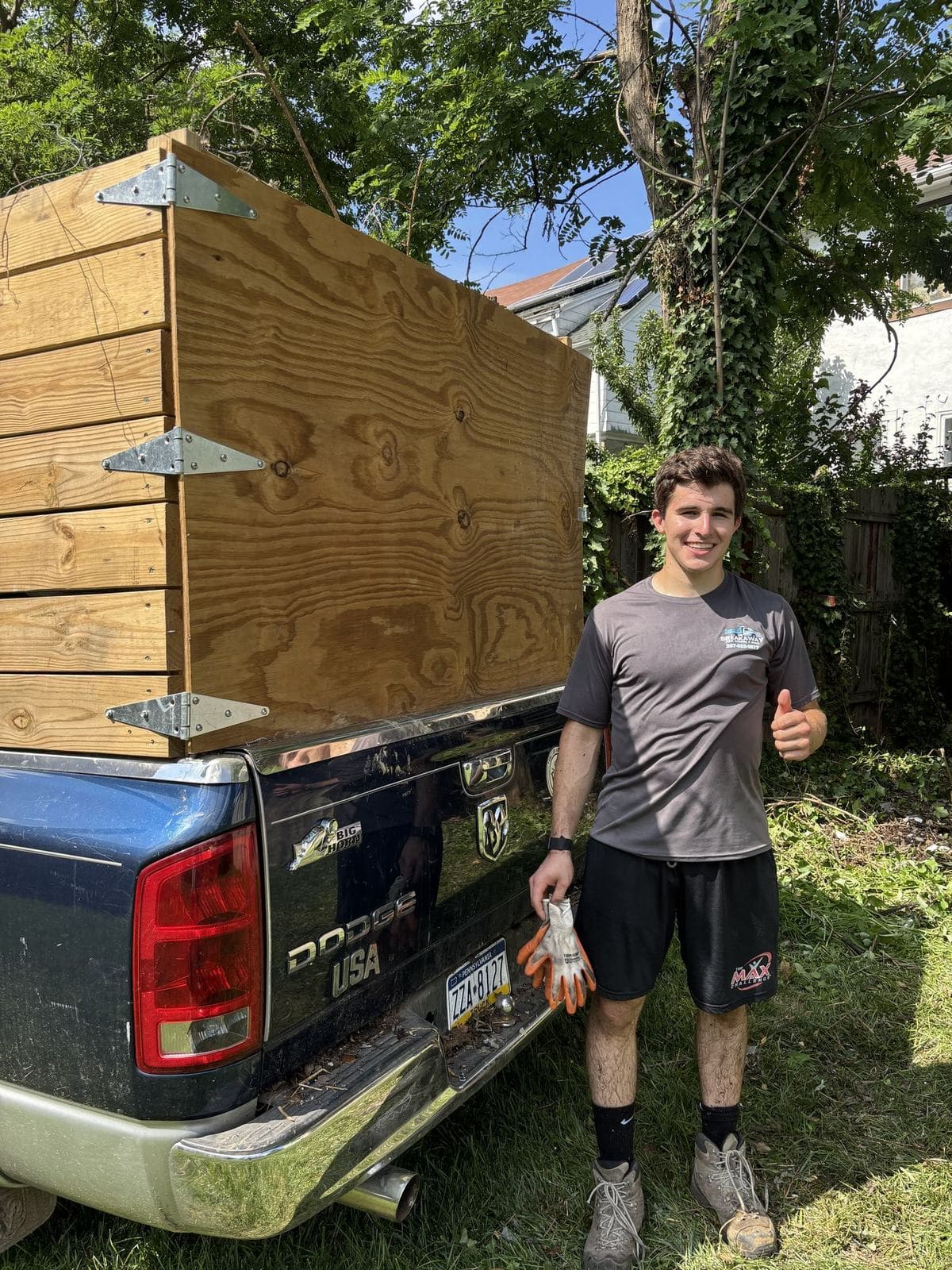 A crew member next to a pickup loaded with a large wooden crate