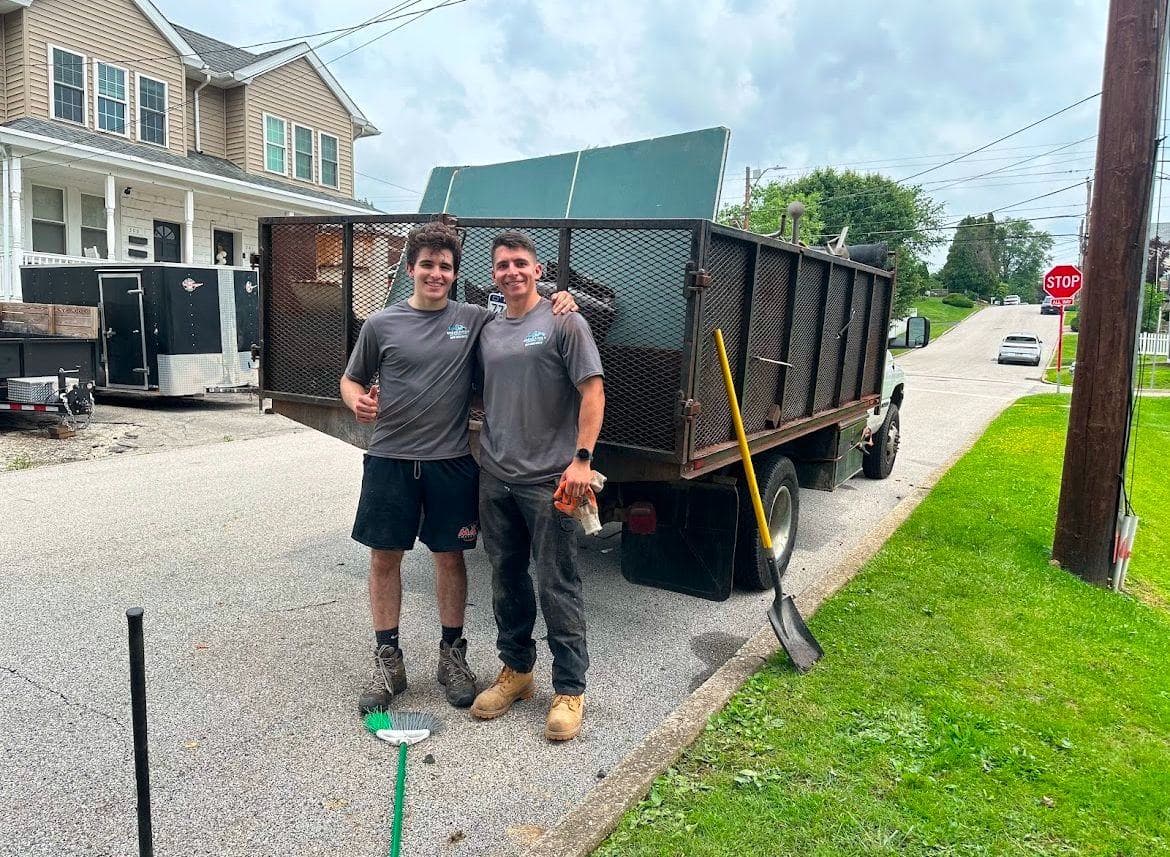 Two crew members beside a trailer full of debris