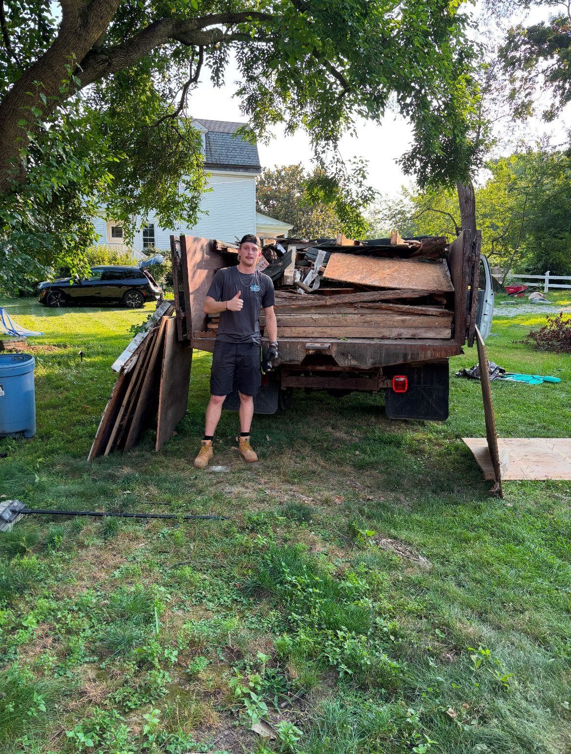 A trailer loaded with construction debris on a lawn