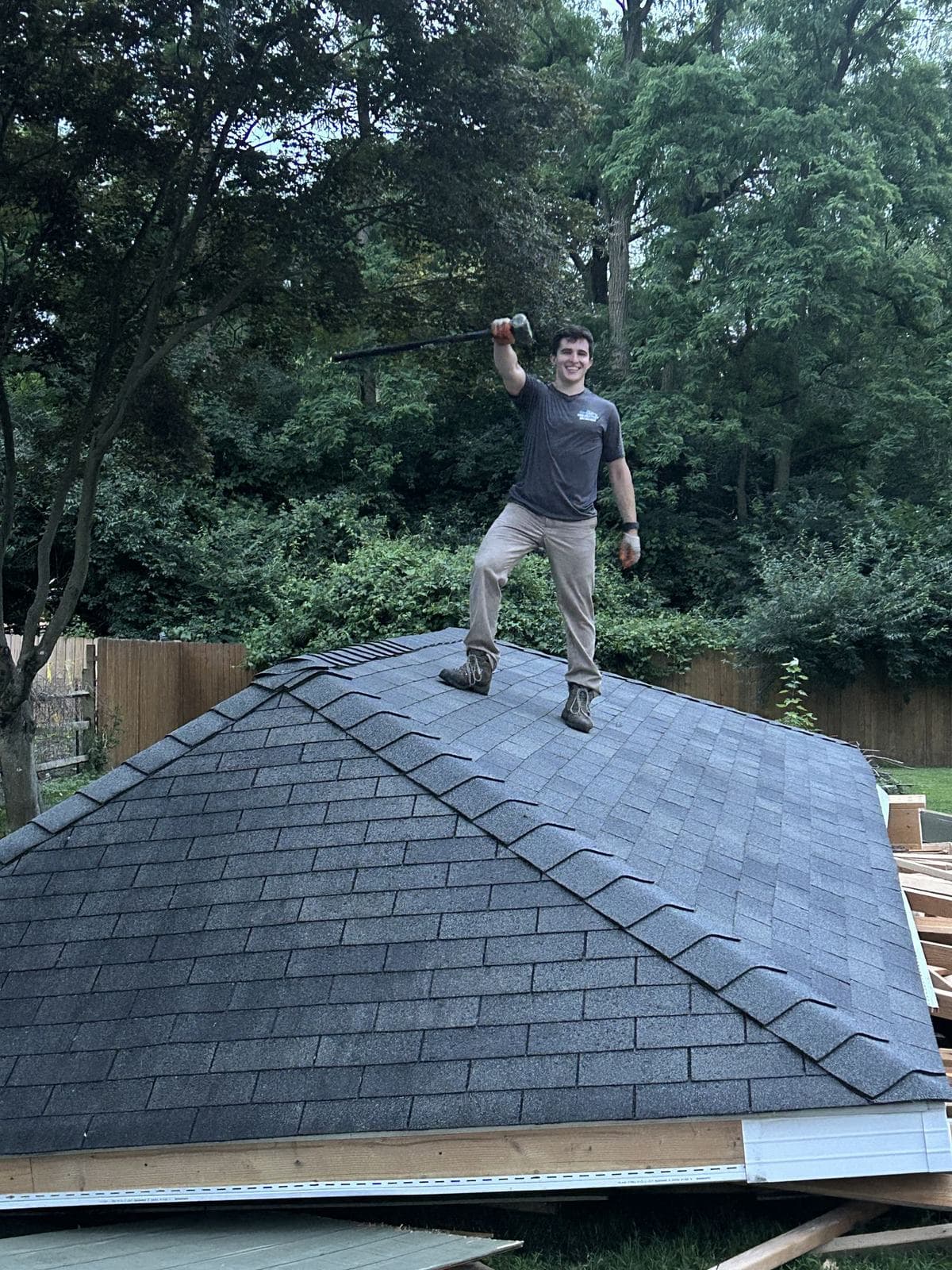 A crew member standing on a shed roof that has been taken down